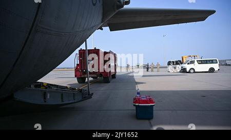 Des aviateurs américains du 75th e Escadron de transport aérien expéditionnaire et du 726th e Escadron de la base aérienne expéditionnaire chargent un camion d'incendie remis à neuf sur un Hercules C-130 sur la ligne de vol du Camp Lemonnier, à Djibouti, le 18 août 2022. Avec la livraison des trois camions d'incendie, le centre de récupération du personnel peut étendre sa portée pour aider plus de personnes à l'aérodrome militaire de Baledogle, en Somalie. (Photo de la U.S. Air Force SSgt Branden Rae) Banque D'Images