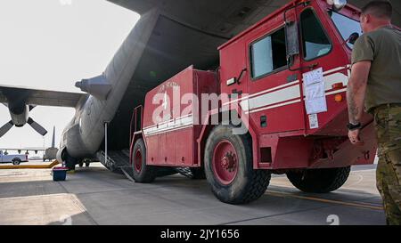 Des aviateurs américains du 75th e Escadron de transport aérien expéditionnaire et du 726th e Escadron de la base aérienne expéditionnaire chargent un camion d'incendie remis à neuf sur un Hercules C-130 sur la ligne de vol du Camp Lemonnier, à Djibouti, le 18 août 2022. Ces camions de pompiers permettront d'excellentes capacités opérationnelles à l'aérodrome militaire de Baledogle, en Somalie. (Photo de la U.S. Air Force SSgt Branden Rae) Banque D'Images