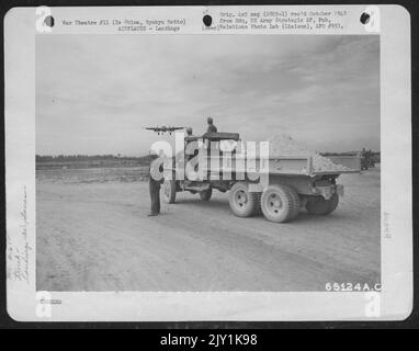 Au sommet D'Un camion de corail, les membres d'un bataillon d'aviation d'ingénieur regardent le premier atterrissage d'Un Northrup P-61 'veuve noire' sur IE Shima, Ryukyu Retto. Banque D'Images