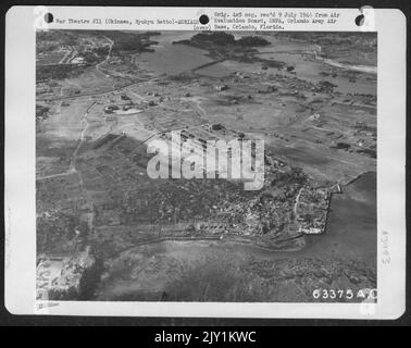 Dans cette photo sont vus les restes de Naha, la capitale d'Okinawa. La zone de la ville a été débarrassée des débris et utilisée pour stocker les fournitures. Le Centre des grands bâtiments à gauche de la photo sont l'Université de Naha. 31 juillet 1945. Banque D'Images