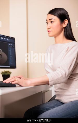 Technicien féminin travaillant sur l'ingénierie des engrenages, utilisant un logiciel technique pour fabriquer des machines et des turbines de moteur. Indépendant développant un modèle de construction avec un programme de CAO. Banque D'Images