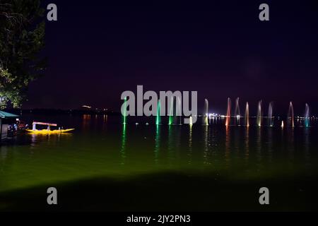 Un homme décale son bateau le long du célèbre lac Dal à Srinagar. Banque D'Images