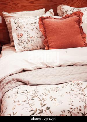 Literie de style campagne vintage avec motif fleuri sur un lit en bois dans la chambre, décoration intérieure Banque D'Images