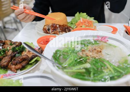 Côtelette de porc grillée avec nouilles de riz et poulet croustillant avec riz aux tomates au Gia Hoi, un restaurant vietnamien de Bankstown — Sydney, Australie Banque D'Images