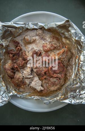 ​​meat émincé de juteux cuit au four est cuit dans le papier d'aluminium. Les épices et les herbes sont enveloppées dans du papier d'aluminium. Porks de cuisson dans le four. Nourriture pour les week-ends et les vacances, Copy Spac Banque D'Images