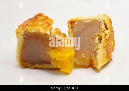 Quartiers de gâteaux de lune traditionnels chinois avec pâte de graines de lotus et jaune d'œuf de canard salé, sur fond blanc Banque D'Images