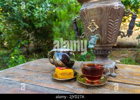 Thé à boire dans un samovar vintage avec des bonbons orientaux Banque D'Images