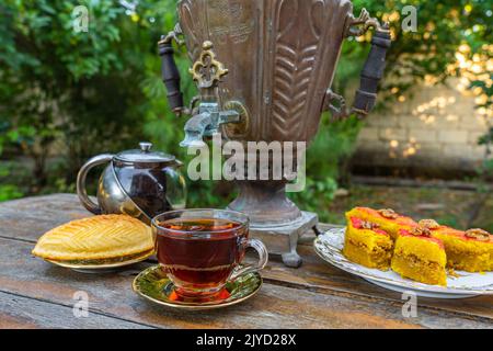 Thé à boire dans un samovar vintage avec des bonbons orientaux Banque D'Images