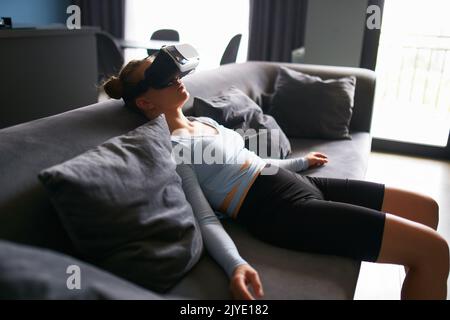 Robot comme une poupée futuriste femme dans la réalité virtuelle masque interface sur la tête entre dans l'expérience réaliste métaverse via le casque. Aspect créepeux Banque D'Images