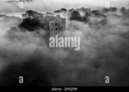 Le château de Norham se lève à travers la brume matinale Banque D'Images