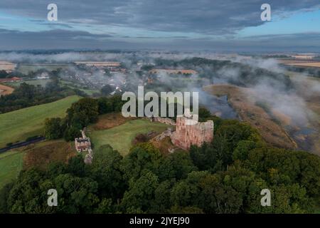 Le château de Norham se lève à travers la brume matinale Banque D'Images