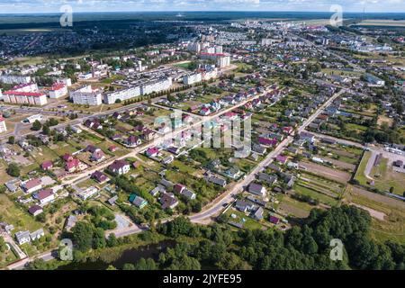 vue panoramique aérienne du village vert avec maisons, granges et route de gravier en forêt Banque D'Images
