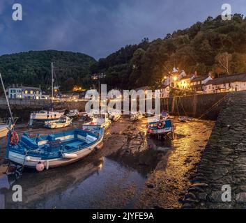 À mesure que la lumière du jour s'estompe, les lumières s'allument autour du petit port pittoresque de Lynmouth, sur la côte nord du Devon. Lynmouth se trouve au confluent de Banque D'Images