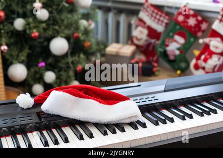 Composition du nouvel an sur un synthétiseur musical. Lumières d'une guirlande.Carte de vœux de joyeux Noël.Bonne année Banque D'Images