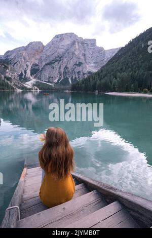 Automne - girl se trouve sur le quai et voir de bien-connu sous le lac Lago di Braies tyrolien Dolomites Italie Banque D'Images