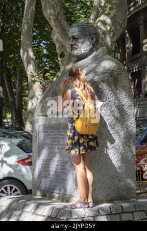 PAMPELUNE: ESPAGNE-AOÛT 5; 2021: Fille touristique près du monument d'Ernest Hemingway (créé en 1968) par Luis Sanguino Banque D'Images