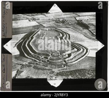 Maiden Castle, situé dans le Dorset, en Angleterre, est l'un des plus grands et des plus complexes collines de l'âge du fer en Europe. La photographie aérienne capture sa vaste échelle et ses travaux de terrassement complexes, mettant en valeur les structures défensives et le paysage environnant. Il reste un site archéologique important, offrant un aperçu des anciens modèles de peuplement et des techniques de fortification. Banque D'Images
