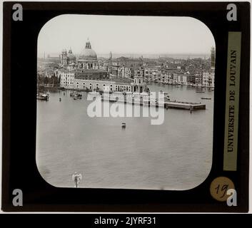 Punta della Dogana est un site important de Venise, connu pour sa maison de douane historique et son bâtiment emblématique de forme triangulaire. Il se trouve à l'entrée du Grand canal, offrant une vue sur la basilique Santa Maria della Salute. Ce quartier a été historiquement un centre de commerce, et le bâtiment abrite aujourd'hui la collection d'art contemporain de la Fondation François Pinault. Le site représente un mélange d'histoire maritime de Venise et d'importance culturelle moderne. Banque D'Images