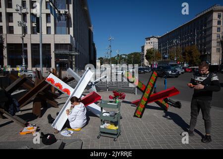 Des artistes peignent des barricades anti-tank de hérisson dans le centre de Kiev. Banque D'Images