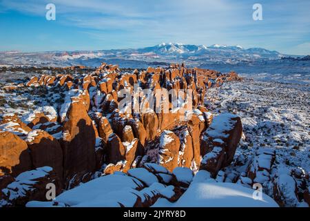 Neige sur les nageoires en grès Entranda de Fiery Furnace avec les montagnes enneigées de la Sal derrière. Parc national Arches, Moab, Utah. Banque D'Images