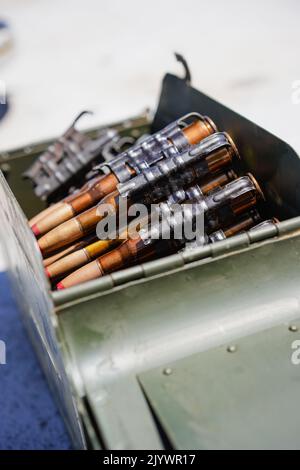 Gros plan d'une courroie de mitrailleuse chargée de cartouches, dans une boîte de munitions. Banque D'Images