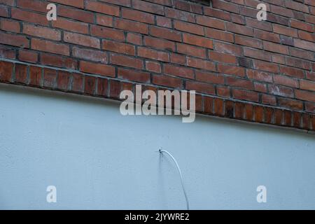 gros plan d'un nouveau bâtiment avec des briques rouges et un mur blanc avec un seul câble Banque D'Images