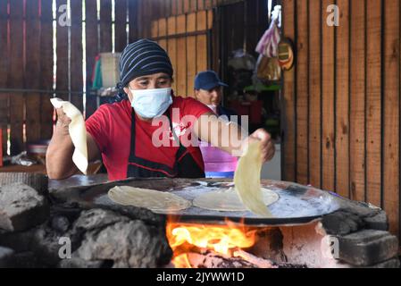 Femme cuisant Tlayudas sur un feu de bois, Oaxaca México Banque D'Images