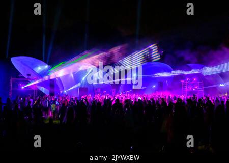 Lumières laser colorées qui brillent et se déplacent sur la foule dansante pendant la fête du DJ à la plage Banque D'Images