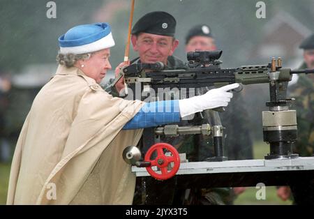 Photo du dossier datée du 09/07/93 de la reine Elizabeth II, avec l'instructeur en chef, Small Arms Corp, le col du LT George Harvey, tirant le dernier coup de feu sur un fusil sa 80 standard lorsqu'elle a assisté au centenaire de l'Association des fusiliers de l'Armée à Bisley. La Reine est décédée pacifiquement à Balmoral cet après-midi, a annoncé Buckingham Palace. Date de publication : jeudi 8 septembre 2022. Banque D'Images