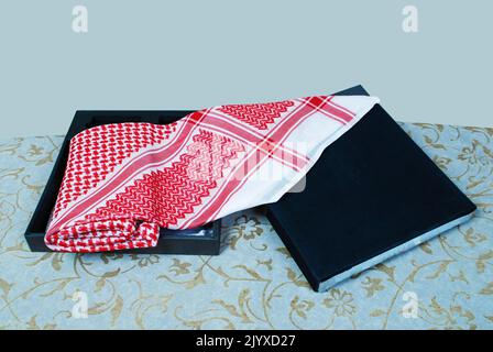 Foulard culturel masculin arabe musulman appelé Shemagh ghutrah isolé rouge et blanc tissu habillement accessoire Moyen-Orient traditionnel Banque D'Images