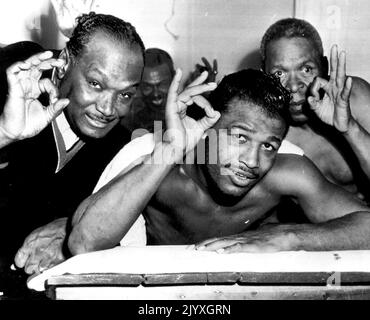 Le champion du monde de boxe « Sugar » Ray Robinson (au centre), son directeur George Gainford (à gauche) et le conditionneur « Soldier » Jones donnent le signe OK alors que Robinson se débaise après son entraînement pour son combat de titre contre Rocky Graziano. 17 avril 1952. Banque D'Images