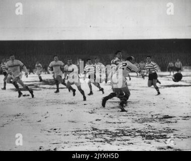 Oldham v Warrington - Rugby League dans la ***** Warrington prend le dessus de la Ligue en battant Oldham à Oldham Davies A. (Oldham) poses à l'ailier australien Barrow (Oldham) quand il est pressé par Brian Bevan (Warrington). 15 janvier 1955. Banque D'Images