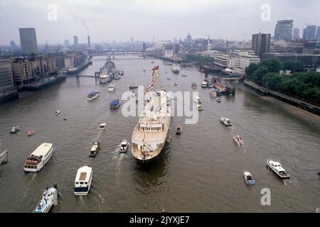 Photo du dossier datée du 9/6/1977 d'une flottille de petites embarcations entourant le yacht royal Britannia dans la piscine de Londres quand la Reine a donné un déjeuner-fête à bord pendant son progrès de la rivière de Greenwich à Lambeth. En arrière-plan est HMS Belfast avec le minesweeper HMS Croften à côté. Le Jubilé d'argent de la Reine en 1977 a vu des millions célébrer son règne lors de fêtes de rue à travers le pays et l'affection que les foules ont manifesté a été une surprise même pour la Reine. Date de publication : jeudi 8 septembre 2022. Banque D'Images