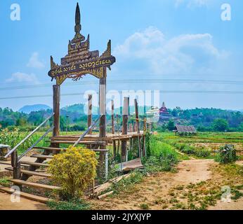 Portail en bois sculpté d'époque du pont en bambou su Tong PAE, longeant les terres agricoles de la banlieue de Mae Hong son, en Thaïlande Banque D'Images