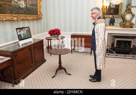 Photo du dossier datée du 18/12/2020 de la reine Elizabeth II apparaissant sur un écran par videolink du château de Windsor, où elle était en résidence, pendant un public virtuel pour recevoir le haut commissaire de la Nouvelle-Zélande, M. Bede Corry, qui a assisté à Buckingham Palace, Londres. La vie de la Reine a été ancrée dans la tradition, mais elle a continué avec les grands progrès technologiques qui se sont produits pendant son règne. Elle a vu l'avènement de la télévision couleur populaire, des téléphones mobiles, d'Internet et des médias sociaux et a tenu des audiences et des réunions par vidéoconférence. Date de publication : jeudi 8 septembre 2022. Banque D'Images