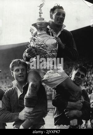 Avril 1952 . . Gus Risman est présidé sur le terrain autre son équipe, Workington, a remporté la coupe de la Ligue. L'australien Tony Paskins se trouve sur la gauche. Vétéran de la ligue de rugby Gus Risman ***** Par des coéquipiers après qu'il ait recueilli la coupe de la Ligue de rugby pour Workington Town à Wembley à gauche est l'australien Tony Paskins. 19 avril 1952. Banque D'Images