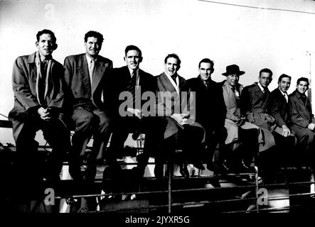 Les Cricketers australiens arrivent en Angleterre -- une partie de l'équipe assise sur les rails à bord des « Orcades » à l'arrivée à Southampton. Ian Craig, « bébé » de 17 ans de l'équipe est cinquième de gauche. Les cricketers australiens, chapeés par Lindsay Hassett, débarquèrent à Southampton depuis le paquebot « Orcades ». 13 avril 1953. (Photo de Sports & General Press Agency Ltd.) Banque D'Images