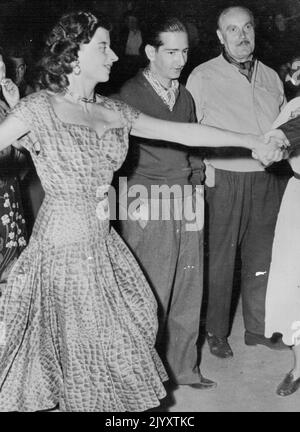 Réconciliation pour le roi Pierre. Salon de photos: Le roi Pierre ne semble pas heureux d'être attiré dans la danse à la tête du village à Arcangues, près de Biarritz, récemment. De nombreuses personnalités célèbres en vacances sur la côte basque, ont assisté à la fête. Une réconciliation est en cours entre le roi Pierre de Yougoslavie et sa femme, la reine Alexandra. Ils se rencontreront bientôt à Paris. Leur première réunion bientôt à Paris. Le roi Peter, Un arrière-arrière-petit-fils de la reine Victoria, a eu beaucoup de problèmes. Le pire problème est qu'il a peu d'argent. 7 septembre 1953. (Photo de Paul Popper photo) Banque D'Images