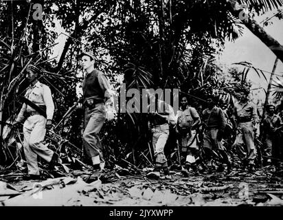 L'officier des États-Unis dirige des Scouts dans la jungle birmane -- en alerte contre les tireurs d'élite japonais, une patrouille de soldats américains et de combattants patriotes birmans, membres d'un détachement scout de l'Armée alliée 14th, est dirigée par un officier de l'armée américaine sur un sentier dans la jungle dans le nord de la Birmanie. Des soldats américains, britanniques et chinois et des patriotes birmans composent les troupes scoutes qui localisent les objectifs japonais, font rapport sur les mouvements ennemis et servent de guides aux troupes alliées dans la campagne contre les Japonais dans le nord de la Birmanie. 06 avril 1944. Banque D'Images
