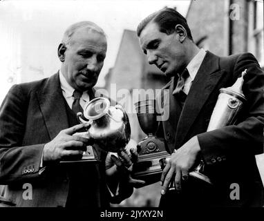 « Comment ça va, papa ? » M. Fred Perry a photographié avec son père à son domicile à ealing aujourd'hui 18th mars. Il est vu montrer à son père quelques-uns de ses nombreux trophées 'cellancected' pendant sa tournée. Le tout-conquérant Perry à nouveau à la maison, Fred Perry, vainqueur des championnats de tennis américain et australien, est de retour à la maison, à Ealing. 24 avril 1934. (Photo de la presse associée). Banque D'Images