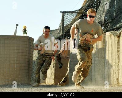 Photo du dossier datée du 03/11/2012 du Prince Harry (à droite) ou simplement du capitaine Wales, connu dans l'Armée britannique, sortant de la tente VHR (très haute disponibilité) pour bousculer son Apache avec d'autres pilotes, Au cours de son quart de 12 heures à la ligne de vol contrôlée britannique à Camp Bastion, dans le sud de l'Afghanistan, où il servait comme pilote d'hélicoptère Apache/Gunner avec 662 corps d'armée de l'air SQD, de septembre 2012 pendant quatre mois jusqu'à janvier 2013. L'ancien soldat a déclaré que le temps qu'il a passé dans l'armée, quand il était 'juste Harry', était 'la meilleure évasion que j'aie jamais eu' et il avait envisagé de donner Banque D'Images