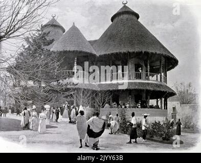 Exposition universelle (Foire mondiale) Paris, 1900; photo en noir et blanc de l'exposition de la Guinée française montrant un pavillon avec deux maisons indigènes avec un relief décoratif. Banque D'Images