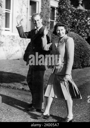 23 novembre 1947 - Romsey, Angleterre, Royaume-Uni - les jeunes mariés LA PRINCESSE ELIZABETH et LE PRINCE PHILIP se mettent à brandir sur les terrains de Broadlands à Romsey, dans le Hampshire, où ils passent leur lune de miel. Le mariage a été vu comme la première lueur d'espoir dans un Commonwealth d'après-guerre, et, bien que le couple royal ait reçu plus de 2 500 cadeaux de mariage du monde entier, le rationnement a exigé que la princesse sauve ses coupons de ration pour acheter le matériel pour sa robe de mariage. (Image de crédit : © Keystone Press Agency/ZUMA Press Wire) Banque D'Images