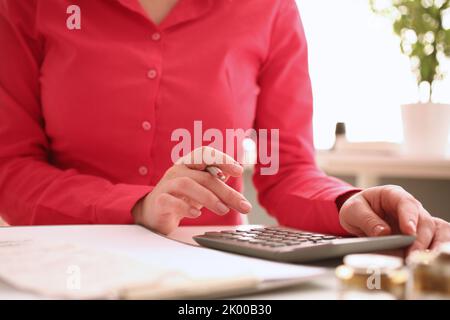 Femme secrétaire compte sur la calculatrice dans le bureau de proximité Banque D'Images