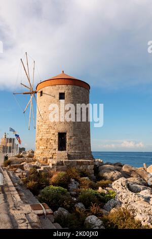 Vue panoramique colorée sur les moulins à vent et les yachts dans le port de Mandraki au coucher du soleil, Rhodes Grèce. Photo de haute qualité Banque D'Images