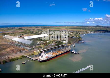 Vue aérienne d'un cargo en cours de chargement dans un terminal par la côte avec un ciel bleu profond au-dessus de Port Bundaberg Qld Australie Banque D'Images