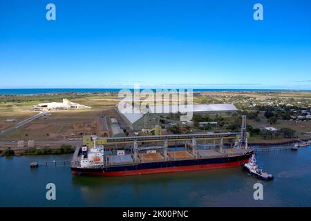 Vue aérienne d'un cargo en cours de chargement dans un terminal par la côte avec un ciel bleu profond au-dessus de Port Bundaberg Qld Australie Banque D'Images