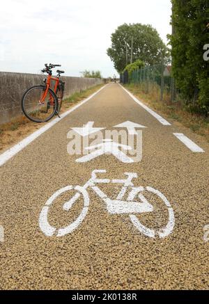 vélo sur la piste cyclable dans la plaine et le symbole blanc dessiné sur l'asphalte Banque D'Images