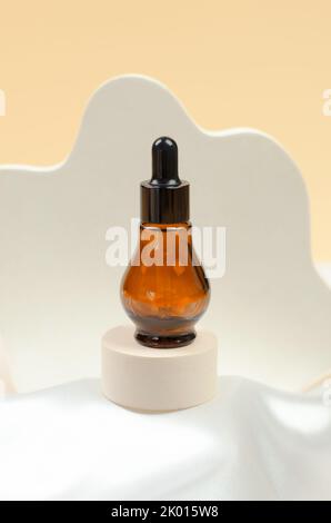 Huile essentielle naturelle ou sérum dans un flacon avec une pipette sur un podium gris. Sérum hyaluronique naturel en flacons avec pipette Banque D'Images