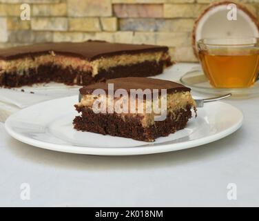 Gâteau de bounty sur plaque blanche avec une cuillère et une sauce caramel Banque D'Images